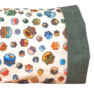 This pillowcase is a perfect gift for the National Parks enthusiast in your life.  Standard Size measures 30" x 20" One pillowcase Washing Instructions: Machine Wash Cold/Tumble Dry Low Product designed and sewn by AdventureUs in Northern Wisconsin  Materials: 100% cotton Riley Blake Designs™ National Parks Badges fabric