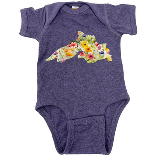 This wisteria purple 100% cotton baby onesie features a Lake Superior image filled by watercolor style flowers in pink, purple, yellow and green.