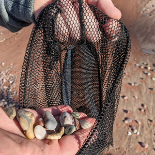 This mesh drawstring bag is the perfect accessory for all your nature walks, whether you're beachcombing or hiking in the woods.    Great for agate & rock hunting, foraging, beach glass collecting, sea shells, pinecones, and as a beachcomber tote. Large size is ideal for sand toys and swim suits Made with 90% Eco-friendly Upcycled Manufactory Leftover "Deadstock" Fabric Strong, durable bag to carry Agates, Yooperlites® rock or those gorgeous flat Lake Superior stones for stacking.