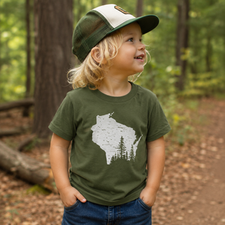 Kid wearing a green t shirt featuring a picture of the state of Wisconsin while playing in a forest.