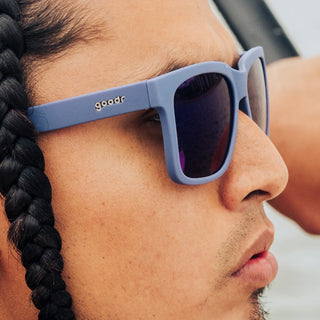 Person wearing goodr sunglasses. These floating sunglasses are the ultimate plus-one for pool parties and I'M ON A BOAT moments. Featuring light blue Tidal G frames and blue reflective water-repellent lenses, you'll look like a paddleboarding pro!
