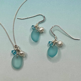 Tumbled matte aqua blue glass creates a soft contrast to the satin finish of Freshwater Pearls.

Sterling silver hooks

Aquamarine blue high quality Crystal

Local Artist&nbsp;