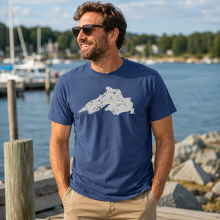 Man wearing a blue t-shirt with a graphic design standing by a marina. AdventureUs Lake Superior Vintage Print T Shirt - Lifestyle