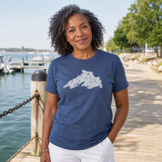 Woman wearing a blue t-shirt with a white graphic design, standing on a dock by water. AdventureUs Lake Superior Vintage Print T Shirt - Lifestyle