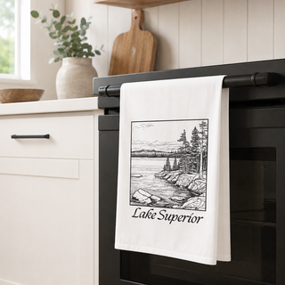 Kitchen towel with 'Lake Superior' design hanging on a stove handle