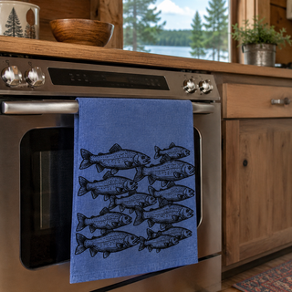 Blue towel with fish pattern hanging on a kitchen oven