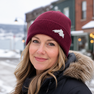 Woman outside wearing an organic cotton knit hat featuring a Lake Superior embroidered patch designed and applied by AdventureUs in Washburn Wisconsin.