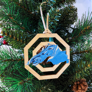 Each piece showcases unique patterns making it a one-of-a-kind addition to your holiday decor. Hang it on your tree or display it in your home to celebrate the season with a touch of nature’s artistry. Perfect as a gift or a cherished keepsake, this ornament captures the spirit of the holidays and the timeless beauty of Lake Superior.

Laser cut birch wood, measures about 3.75 in wide x 4 in tall, is strung with white leather string and packaged in a cellophane bag with backing card.&nbsp;