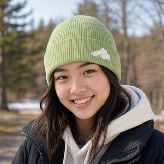 Woman outside wearing an organic cotton knit hat featuring a Lake Superior embroidered patch designed and applied by AdventureUs in Washburn Wisconsin.