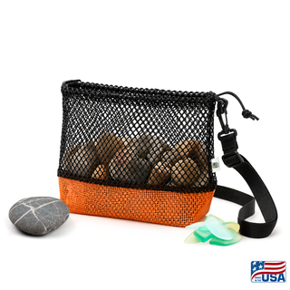 Orange and Black AdventureUs mesh collecting bag with carrying strap for agate hunting, rock collecting, mushroom foraging, and beachcombing. Filled with rocks with nature items around for featured suggested use.