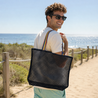 Man with a black mesh tote bag on a beach