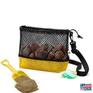 Yellow and Black AdventureUs mesh collecting bag with carrying strap for agate hunting, rock collecting, mushroom foraging, and beachcombing. Filled with rocks with nature items around for featured suggested use.