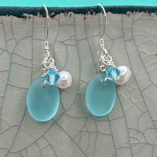 Tumbled matte aqua blue glass creates a soft contrast to the satin finish of Freshwater Pearls.

Sterling silver hooks

Aquamarine blue high quality Crystal

Local Artist&nbsp;