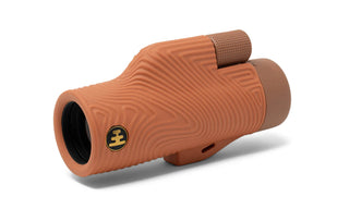 Brown monocular with textured surface on a white background