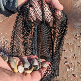 This mesh drawstring bag is the perfect accessory for all your nature walks, whether you're beachcombing or hiking in the woods.    Great for agate & rock hunting, foraging, beach glass collecting, sea shells, pinecones, and as a beachcomber tote. Large size is ideal for sand toys and swim suits Made with 90% Eco-friendly Upcycled Manufactory Leftover "Deadstock" Fabric Strong, durable bag to carry Agates, Yooperlites® rock or those gorgeous flat Lake Superior stones for stacking. 